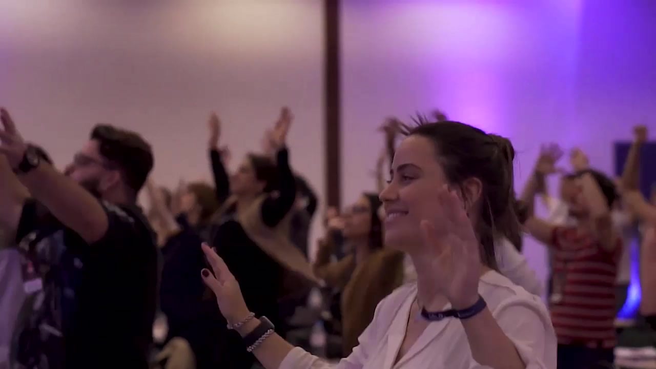 Kairam Cabral no palco, plateia de pé durante um evento