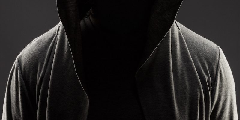 man in the hood over grey background